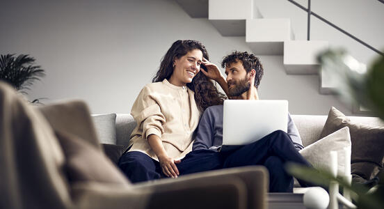 Par i soffa med laptop