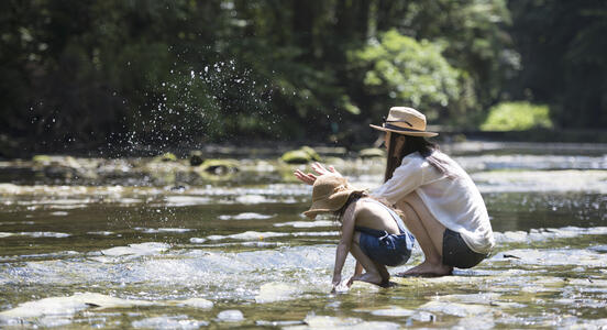 Mother and daughter playing at a river